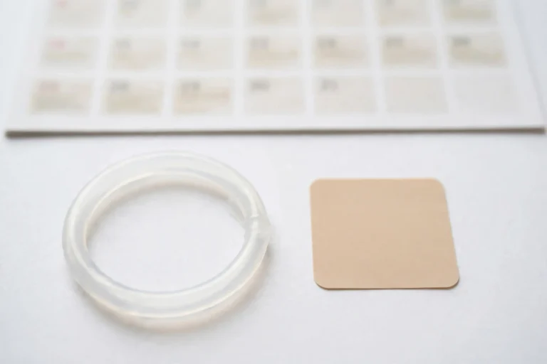 Flat-lay photo comparing a vaginal ring vs patch contraception options beside a monthly calendar
